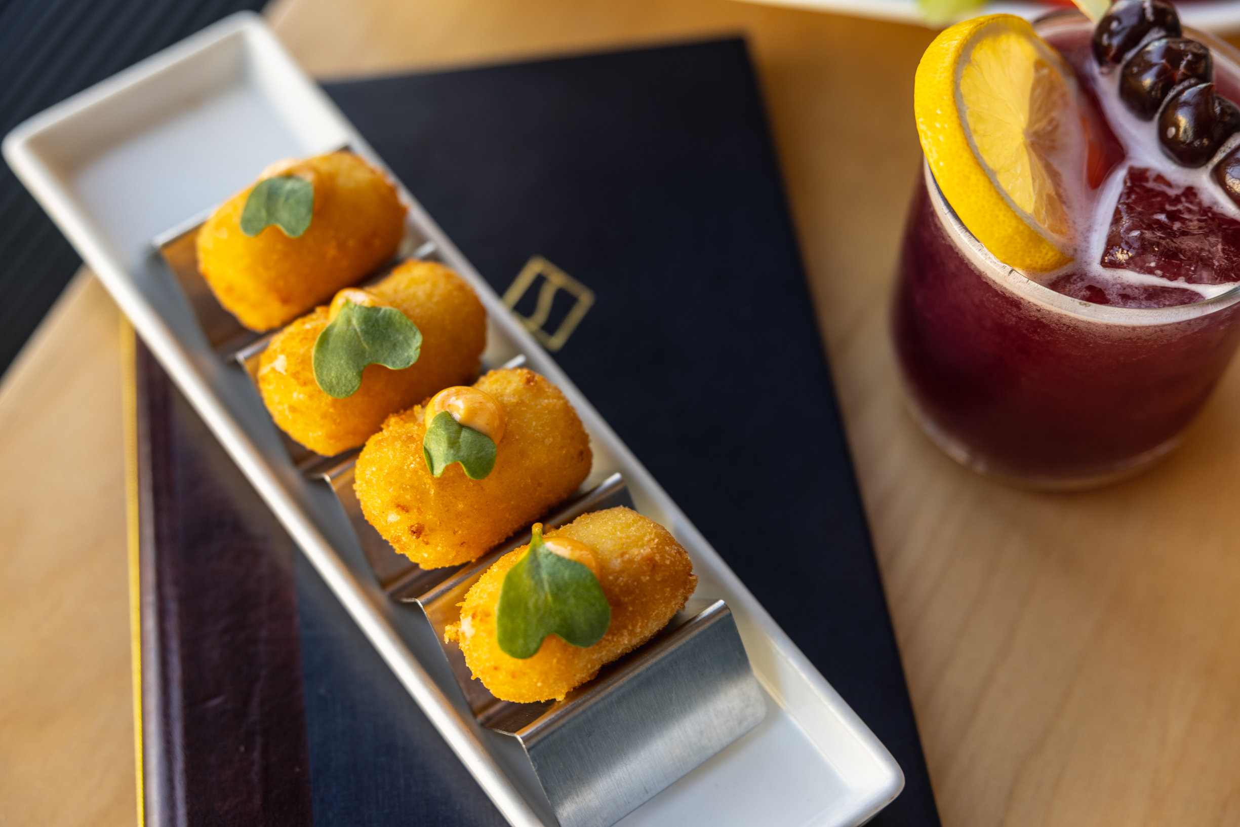 spicy queso croquette and bourbon street cocktail at the bar and lounge and event space the skylark nyc in midtown manhattan